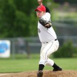 A baseball pitches winds up for release on a pitch.