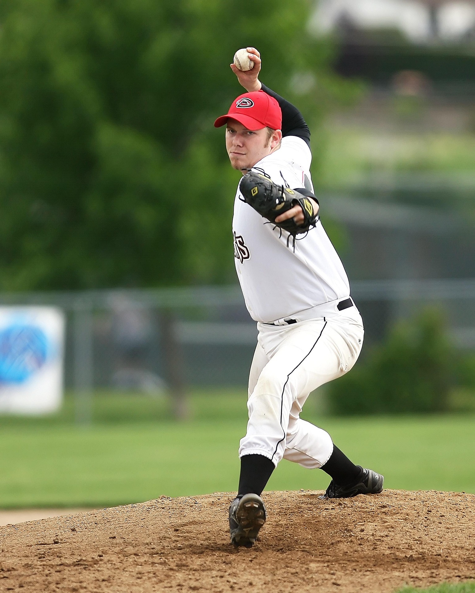 A baseball pitches winds up for release on a pitch.