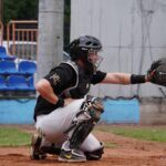 A baseball catcher is ready for the next pitch.