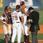 There is a meeting on the mound between the pitcher and the catcher.