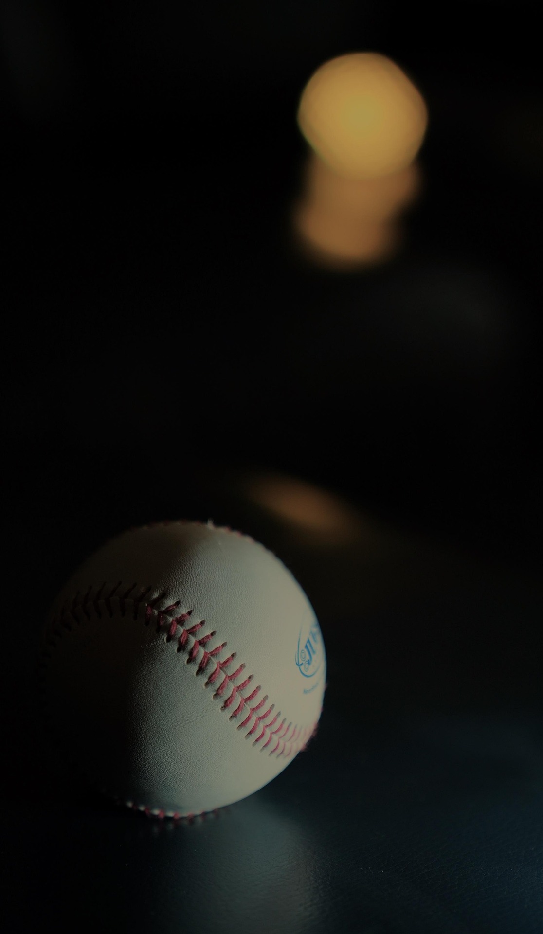 Baseball in low light, half in shadow, symbolizing Astros injury struggles