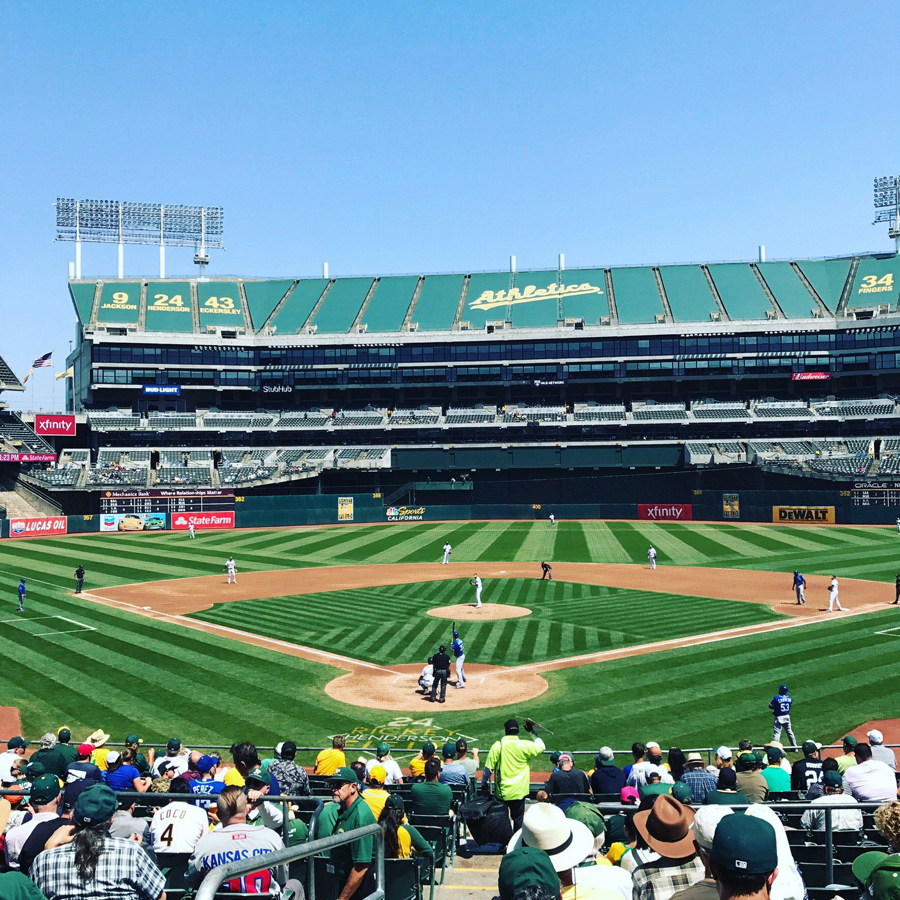 A crowd watching an afternoon game at the Athletics' park.