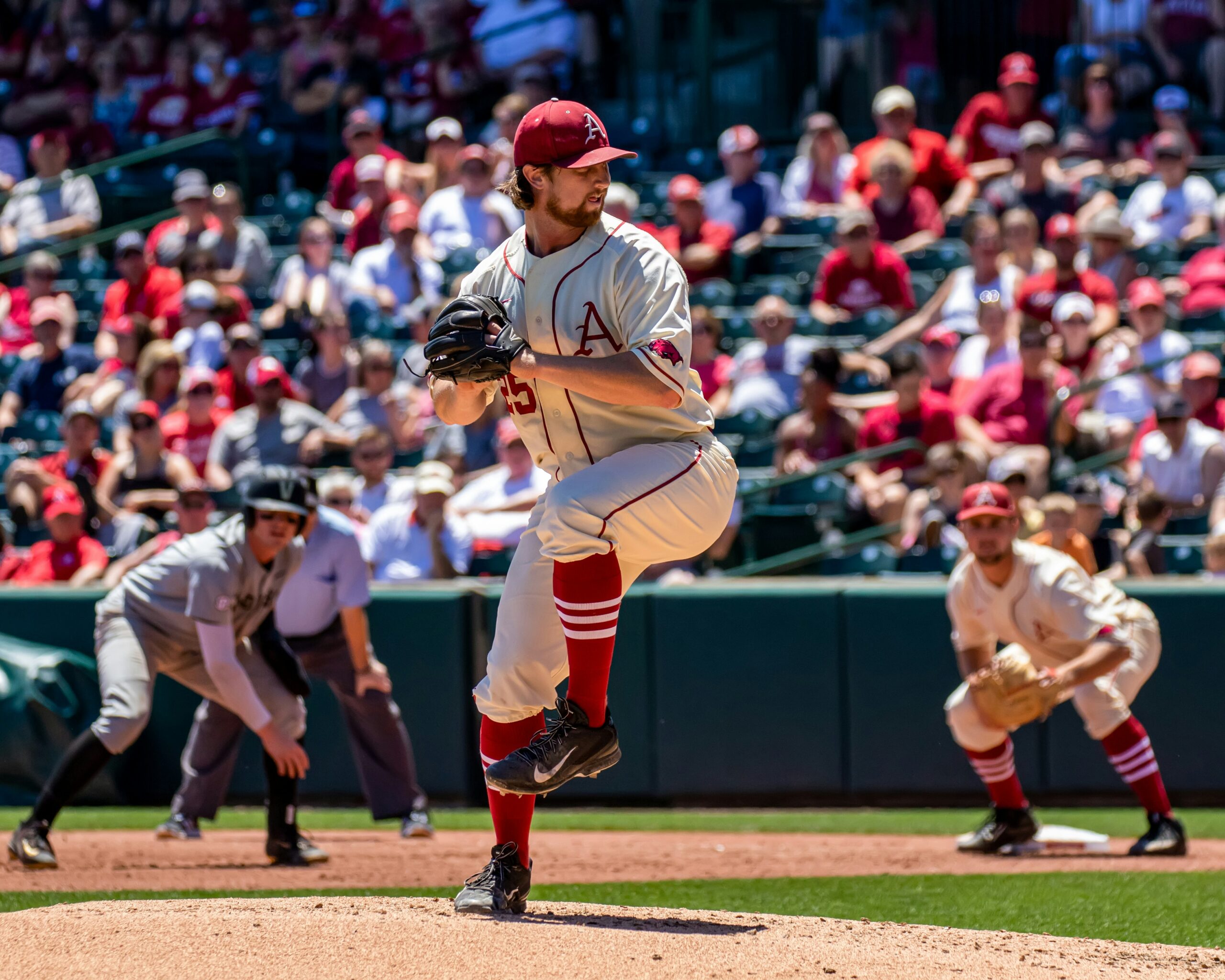 A pitcher standing on the mound winds up for the release.