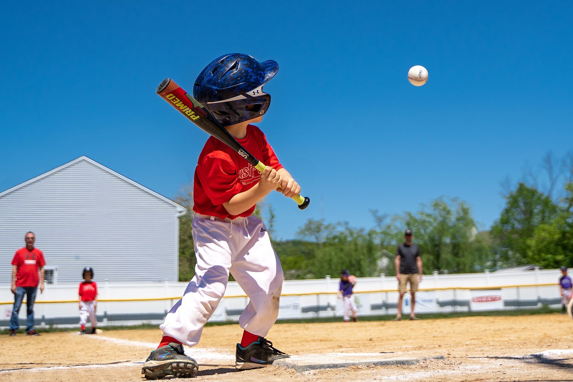 A baseball player is batting at the plate, watching the ball come toward him.