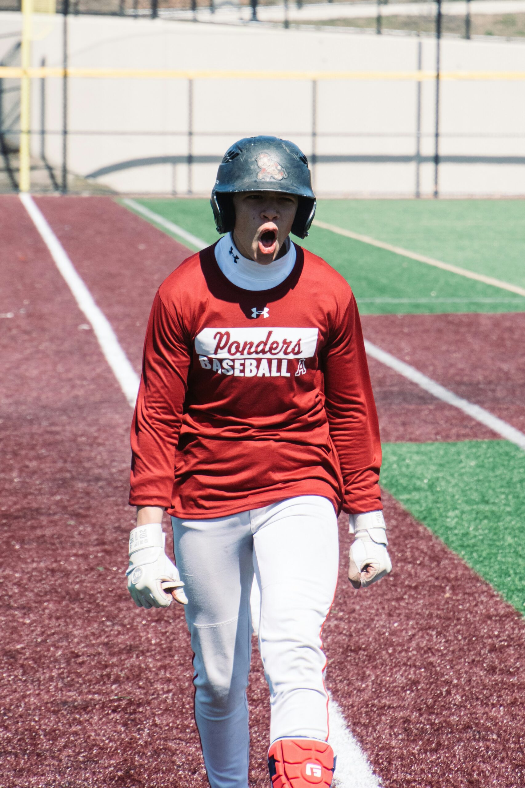 A baseball player yells and clenches his fists in frustration.