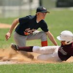 A runner is tagged out after sliding into base.