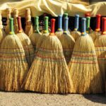 A collection of brooms with different-colored handles.