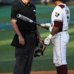 A batter argues with an umpire over a call.