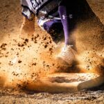 A baseball player slides into base safely.