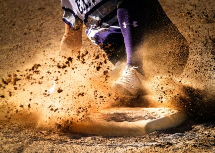 A baseball player slides into base safely.