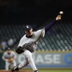 A baseball pitcher hurls a pitch toward home plate.