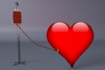 Red heart connected to a blood donation bag and IV stand by a tube, symbolizing blood donation and lifesaving care.