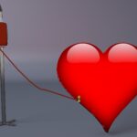 Red heart connected to a blood donation bag and IV stand by a tube, symbolizing blood donation and lifesaving care.