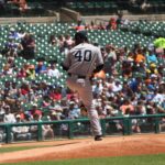 A baseball pitcher is on the mound, winding up.