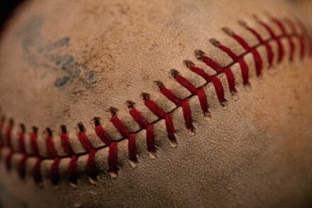 A used baseball with smudges of dirt on it.