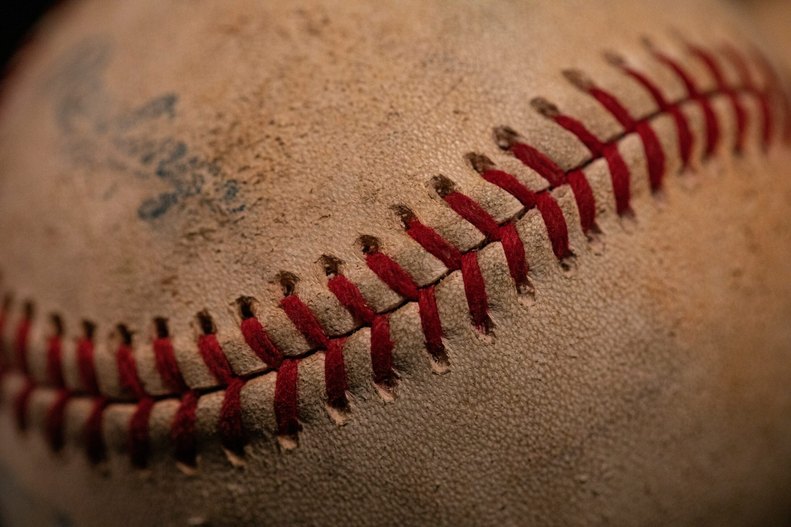 A used baseball with smudges of dirt on it.