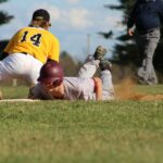 A baseball player attempts to tag out a player who just slid into the base.