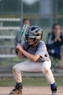 A batter crouches down in readiness.