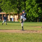 A pitcher is on the mound, winding up for the release.