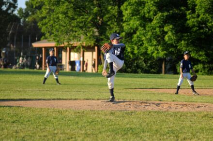 A pitcher is on the mound, winding up for the release.