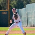 A pitcher winds up, ready for release.