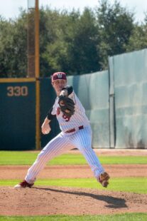 A pitcher winds up, ready for release.