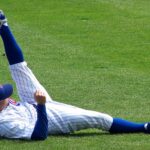A player for the Chicago Cubs stretches on the field.