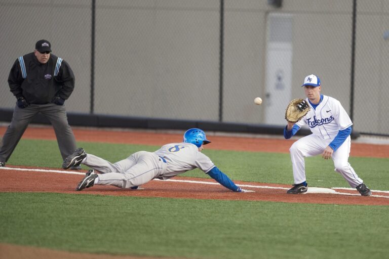 A baseball player slides to the base after trying to steal.