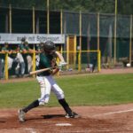 A batter at home plate takes a swing.