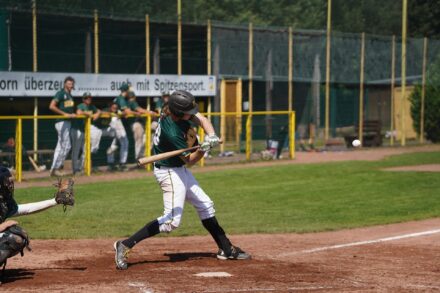 A batter at home plate takes a swing.