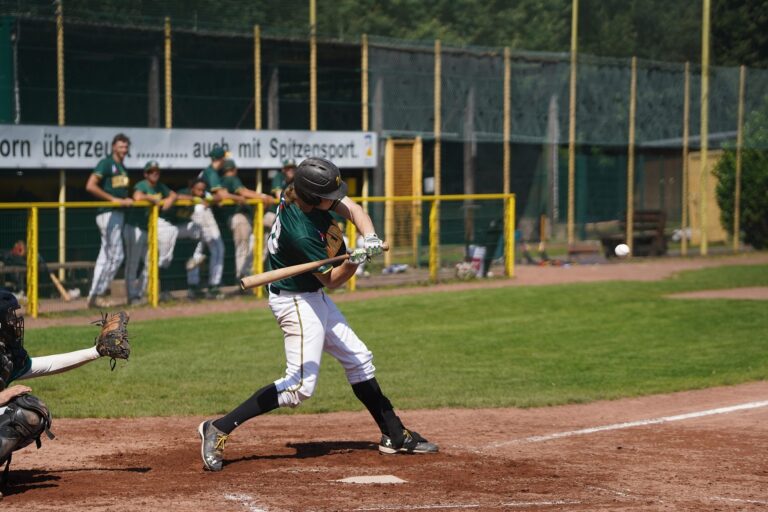 A batter at home plate takes a swing.