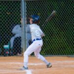 A batter is at the plate, ready for the pitch.