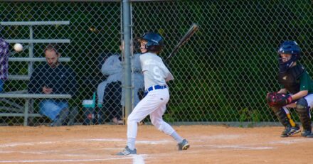 A batter is at the plate, ready for the pitch.