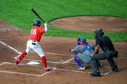A batter at home plate is ready to swing, while the catcher and umpire look on.