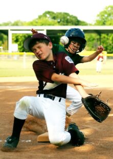 Two baseball players and the ball collide on base.