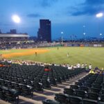 A half-empty baseball field during an evening game.