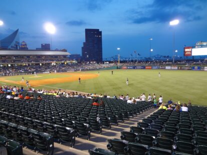 A half-empty baseball field during an evening game.