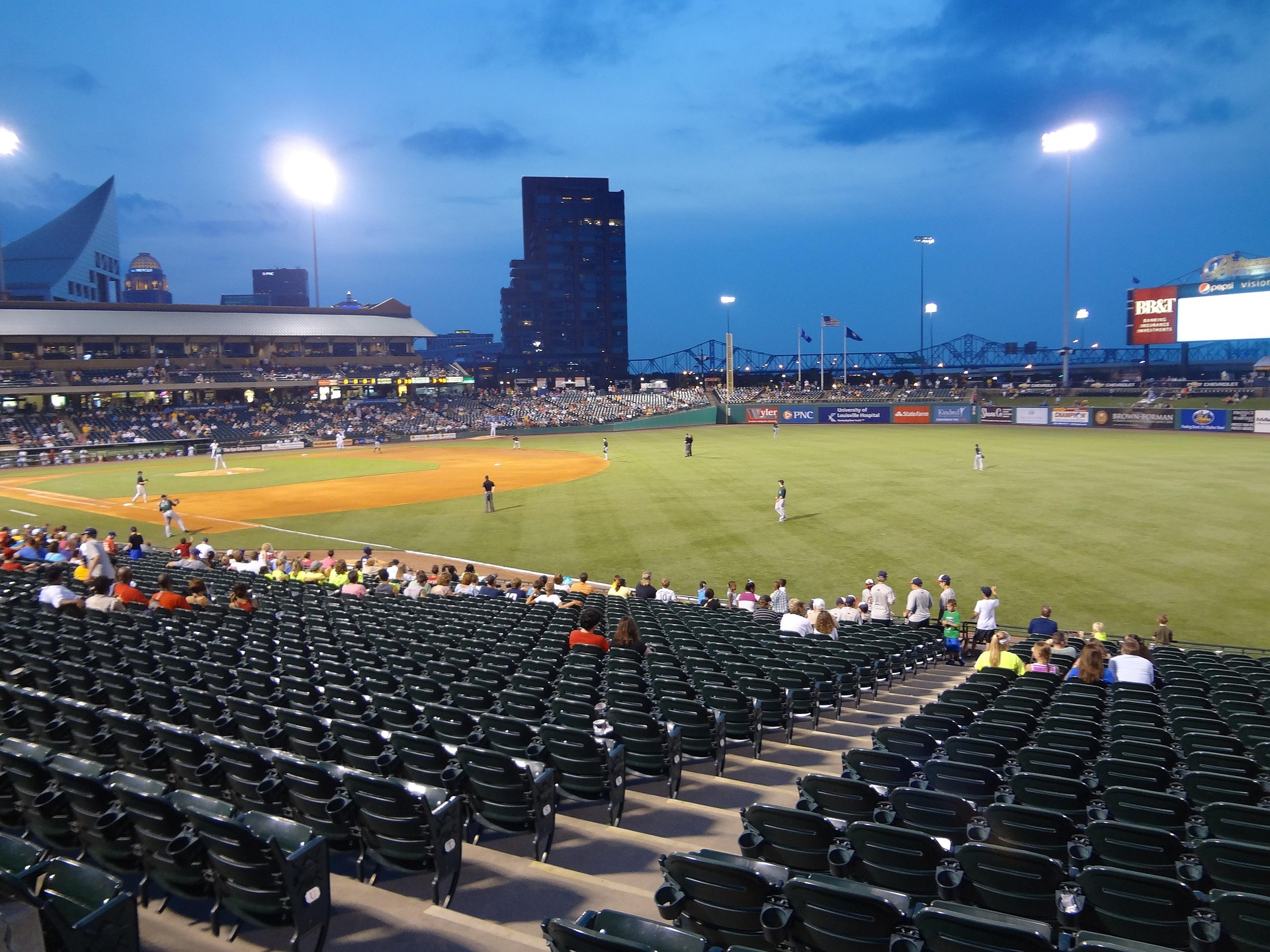 A half-empty baseball field during an evening game.