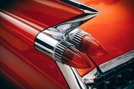 Taillights of a classic car with red fins.