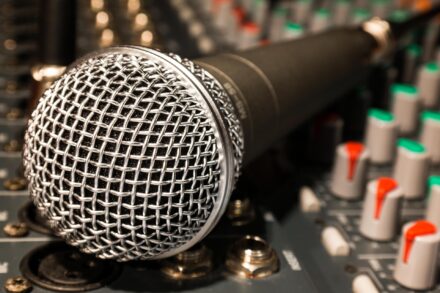 Close-up of a broadcast microphone in a studio.
