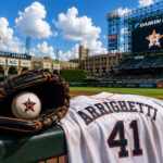 A pitcher's glove and baseball lie on a railing next to a jersey at Daikin Park.
