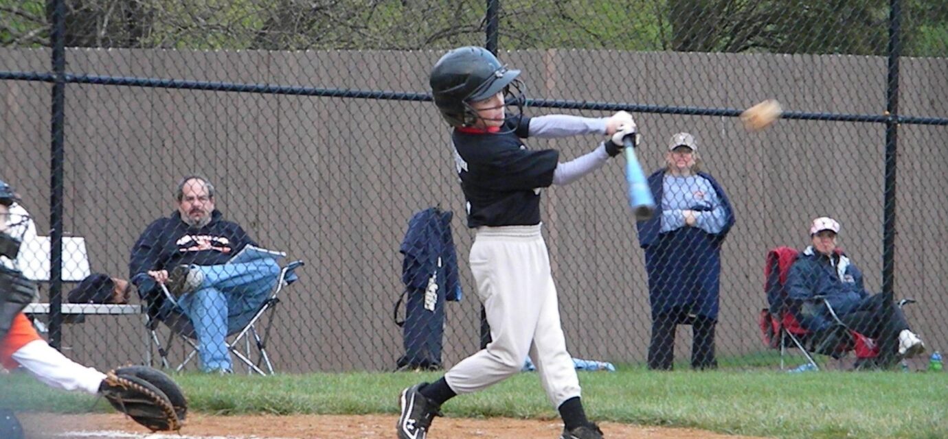 A batter takes a swing at a baseball.