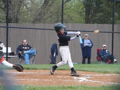 A batter takes a swing at a baseball.