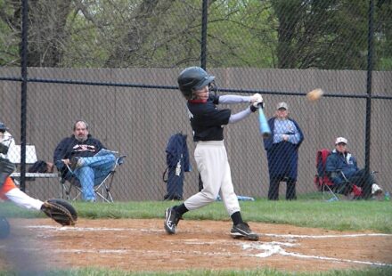 A batter takes a swing at a baseball.