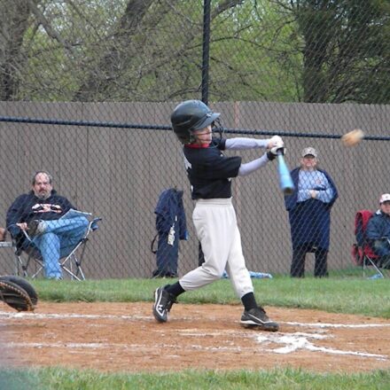 A batter takes a swing at a baseball.