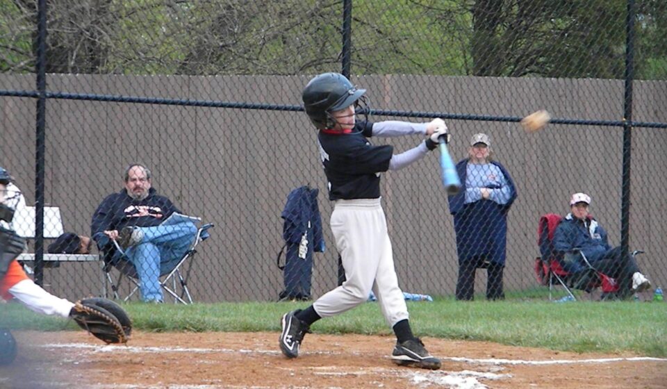 A batter takes a swing at a baseball.