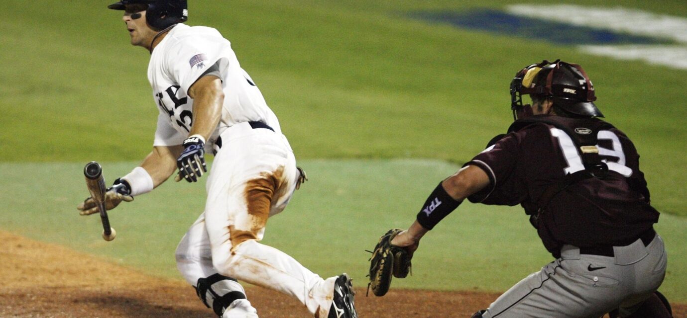 A baseball player begins running to first while dropping his bat.