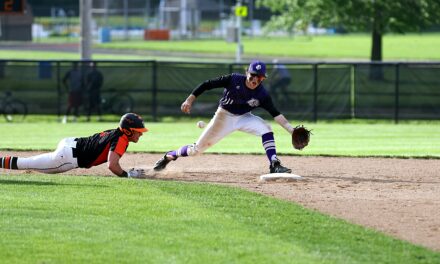 A baseball player slides into the base to avoid being tagged out.