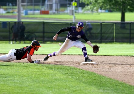 A baseball player slides into the base to avoid being tagged out.
