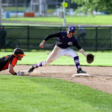 A baseball player slides into the base to avoid being tagged out.